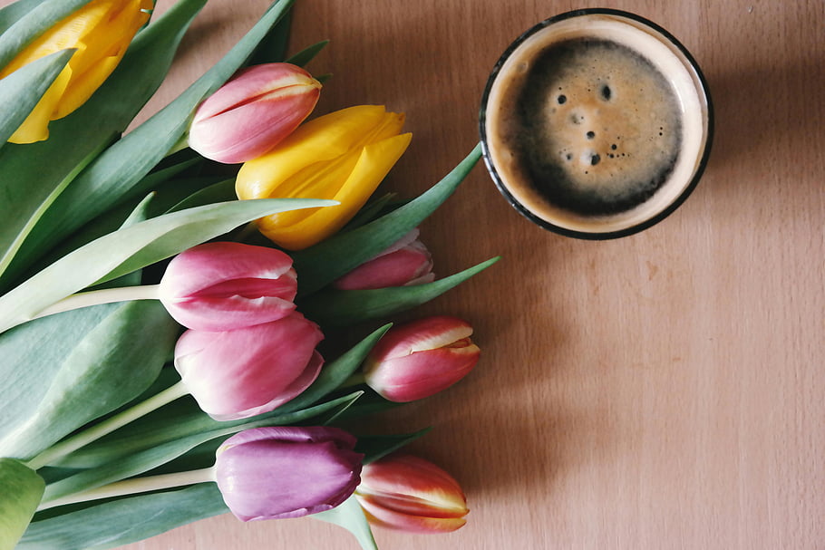 pink-tulips-yellow-tulips-drinking-glass-coffee-cup-wooden-table-top-down-view-vibrant-flowers-floral-arrangement-morning-coffee-spring-flowers.jpg